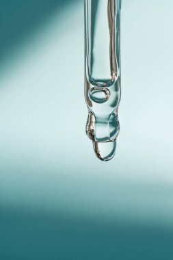 Pipetten bir damla kozmetik yağı düşüyor.