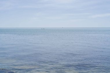 Mavi tonlarda güzel deniz ve gökyüzü manzarası.