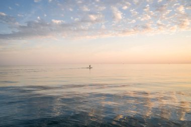 Mavi denizde güzel gün batımı manzarası.