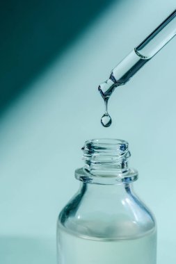 Pipetten bir damla kozmetik yağı düşüyor.