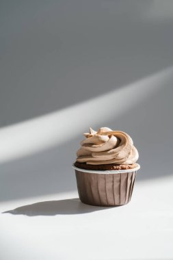 Beyaz, güneşli arka planda, gölgeli bir kek..