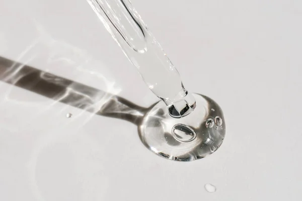 Pipetten bir damla kozmetik yağı düşüyor.