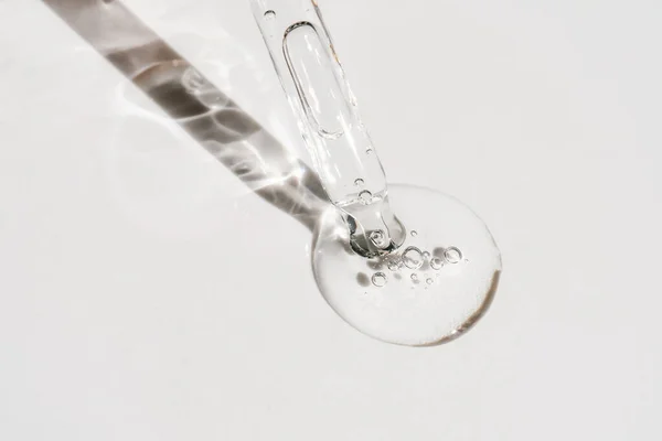 Uma gota de óleo cosmético cai da pipeta — Fotografia de Stock