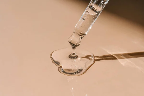 Pipetten bir damla kozmetik yağı düşüyor.