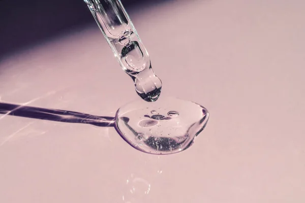 Pipetten bir damla kozmetik yağı düşüyor.