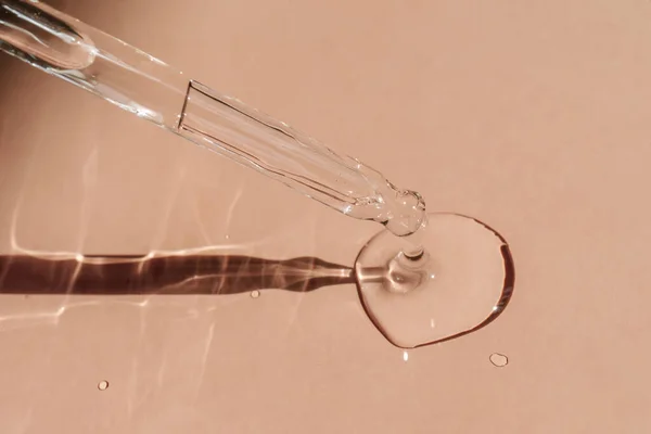 Uma gota de óleo cosmético cai da pipeta. — Fotografia de Stock