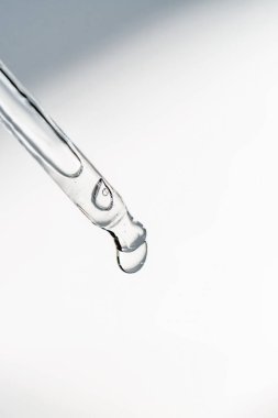 Pipetten bir damla kozmetik yağı düşüyor.