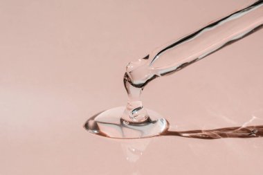 Pipetten bir damla kozmetik yağı düşüyor.