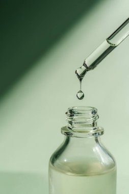Pipetten bir damla kozmetik yağı düşüyor.