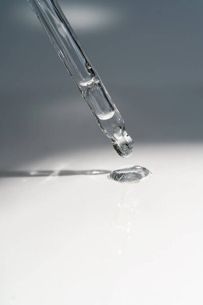 A drop of cosmetic oil falls from the pipette