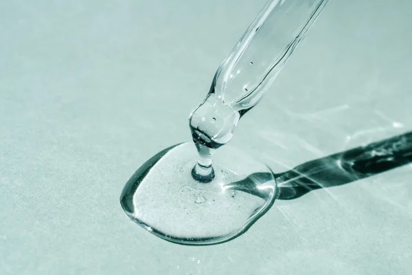 Pipetten bir damla kozmetik yağı düşüyor.