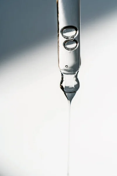 Uma gota de óleo cosmético cai da pipeta — Fotografia de Stock