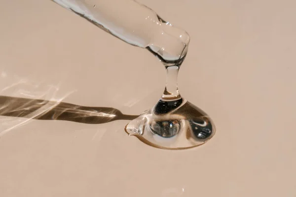 Pipetten bir damla kozmetik yağı düşüyor.