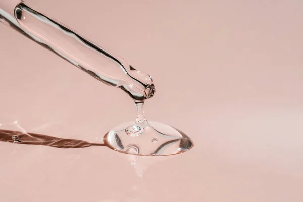 Pipetten bir damla kozmetik yağı düşüyor.