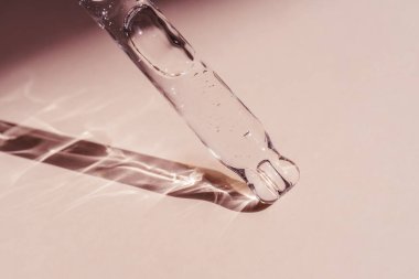 Pipetten bir damla kozmetik yağı düşüyor.