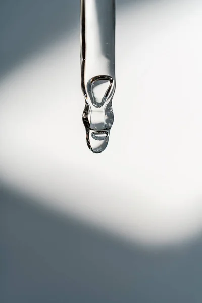 Uma gota de óleo cosmético cai da pipeta — Fotografia de Stock