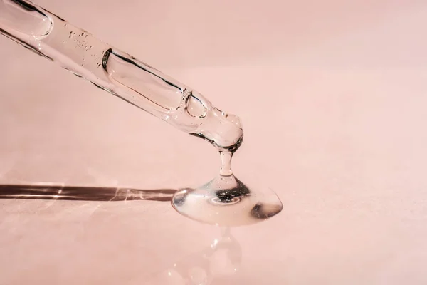 Pipetten bir damla kozmetik yağı düşüyor.