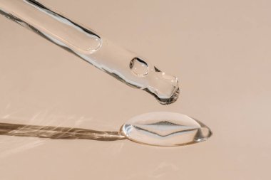 Pipetten bir damla kozmetik yağı düşüyor.