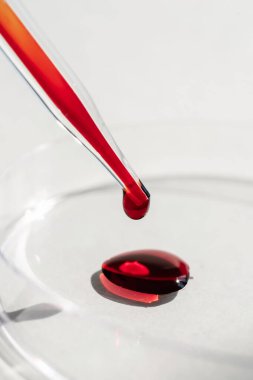 El, içinde kan olan bir test tüpü tutuyor..