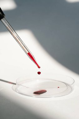 El, içinde kan olan bir test tüpü tutuyor..