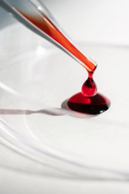 El, içinde kan olan bir test tüpü tutuyor..