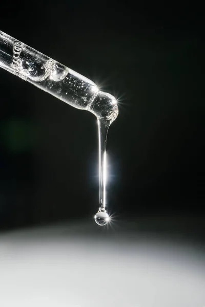 Pipetten bir damla kozmetik yağı düşüyor.