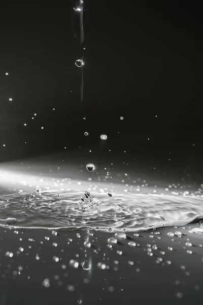 Caída de gotas de agua sobre un fondo de sombra. — Foto de Stock