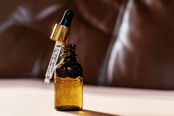 Kabarcıklı kahverengi bir şişede kozmetik yağlı boru.