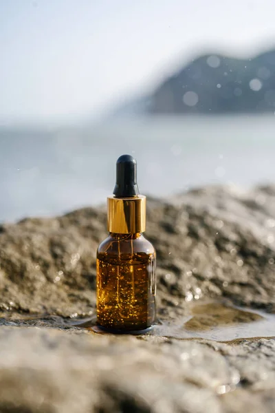 Deniz zemininde taşların üzerinde bir şişe serum..