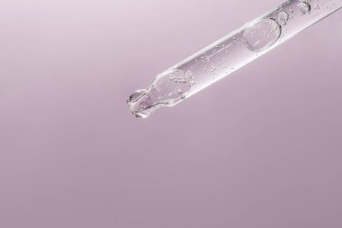 Pipetten bir damla kozmetik yağı düşüyor.