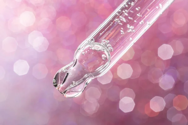 Pipetten bir damla kozmetik yağı düşüyor.