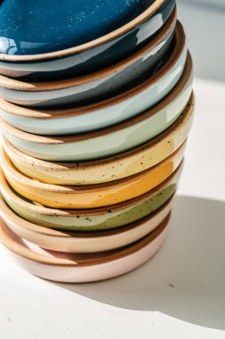 Pastel renkte büyük bir seramik bardak yığını.