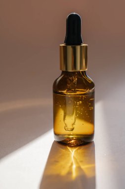 Bej arka planda kahverengi bir serum şişesi..