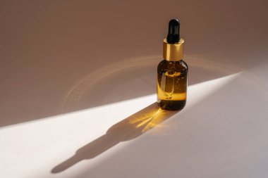 Bej arka planda kahverengi bir serum şişesi..