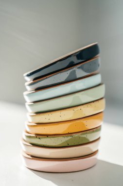 Pastel renkte büyük bir seramik bardak yığını.