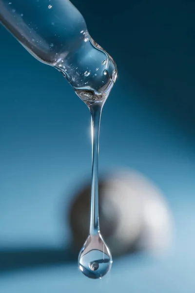 Pipeta com soro transparente no fundo das conchas. — Fotografia de Stock