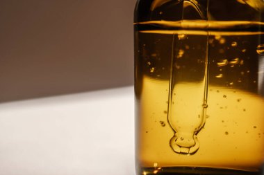 Bej arka planda kahverengi bir serum şişesi..