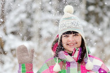 Gülümseyen ve kış orman içinde sallayarak kız
