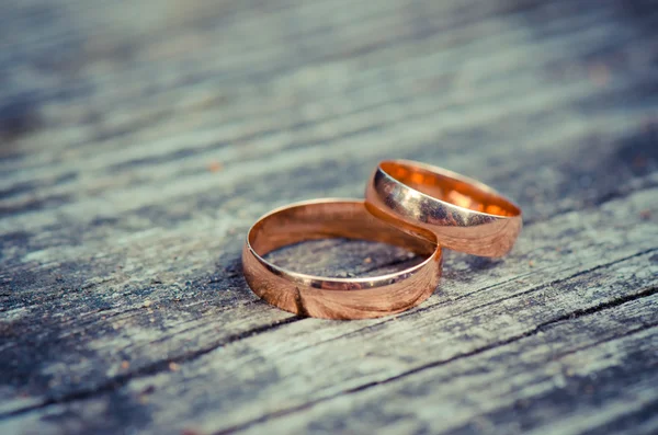 Snubní prsteny na dřevěném prkénku — Stock fotografie