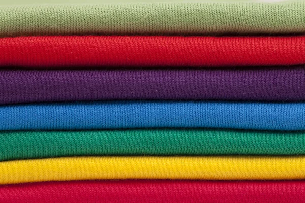En stack av skjortor i ljusa färger — Stockfoto