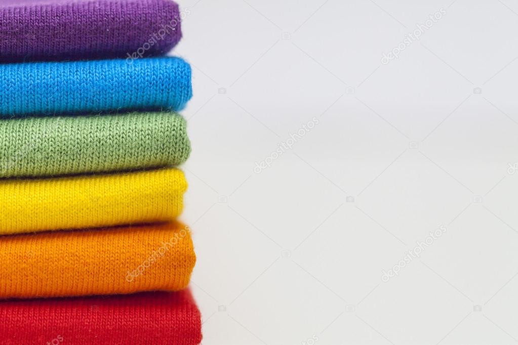 A stack of colourful shirts with space for extra text or logo