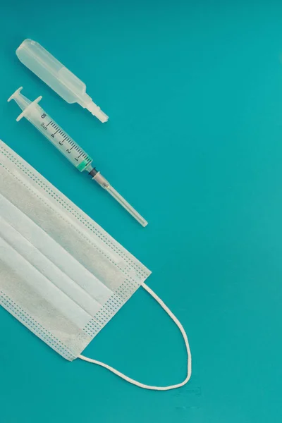 Injectievaccin, ampullen en een spuit met een geneesmiddel, medisch beschermend masker. — Stockfoto