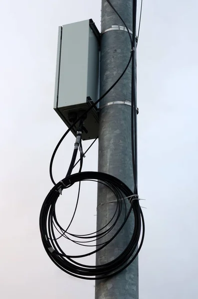 Çelik bir tüp ve bir bobin kablolu bir direğin üzerindeki elektrik kutusu.