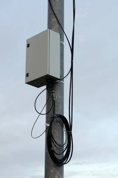 Çelik bir tüp ve bir bobin kablolu bir direğin üzerindeki elektrik kutusu.