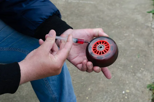 Elindeki şırıngada kayganlaştırıcı var.