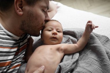 Seni çok seviyorum. Küçük çocuk yatak odasında yatakta dinlenirken esmer bir babanın bebeğini öptüğü portre görüntüsü. Babalık ve mutlu çocukluk kavramı