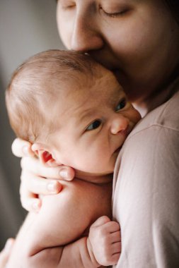 Memnun oldum. Esmer, tapılası bir kadın sabah yatak odasında onunla vakit geçirirken yeni doğmuş bebeğini başından öpüyor. Stok fotoğrafı