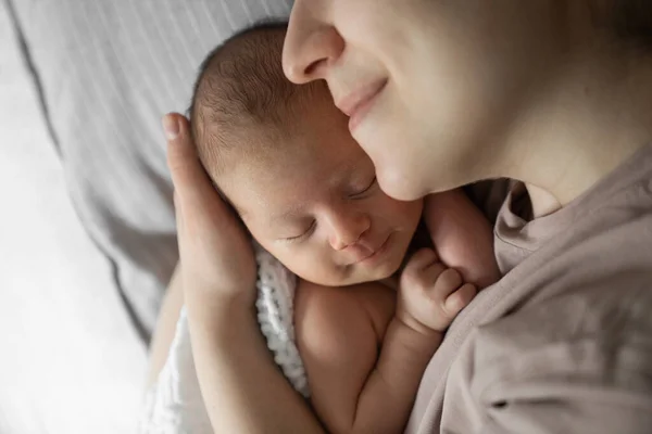 Annelik günlerin kutlu olsun. Sevgili annenin, oğlunun üzerine eğildiği ve yatakta uzanırken sevgi ve özenle ona bağlandığı görüntüler. Stok fotoğrafı