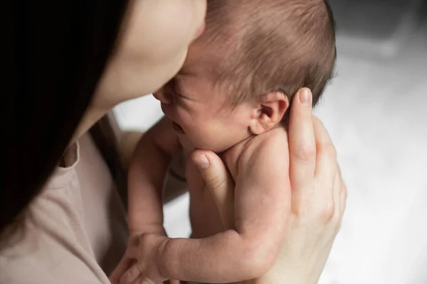 Beyaz bir kadının yatak odasında onunla otururken ağlayan küçük bebeğini sakinleştirdiğini gördüm. Annelik kavramı. Stok fotoğrafı