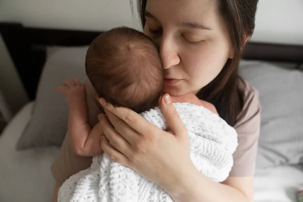 Canım benim. Genç esmer kadın, yeni doğmuş bebeğiyle vakit geçirirken onunla kafa kafaya ve şefkatle gözlerini kapatıyor. Annelik ve mutlu çocukluk kavramı